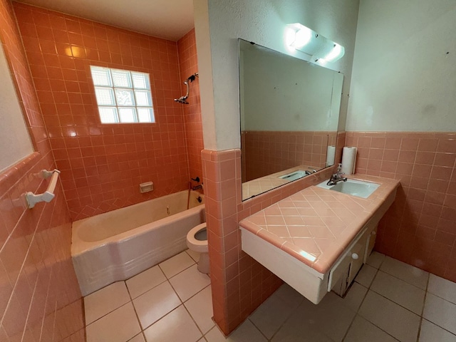 full bath featuring a sink, tile walls, tile patterned flooring, and  shower combination