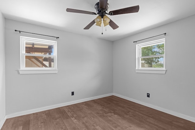 empty room with wood finished floors, baseboards, and a ceiling fan