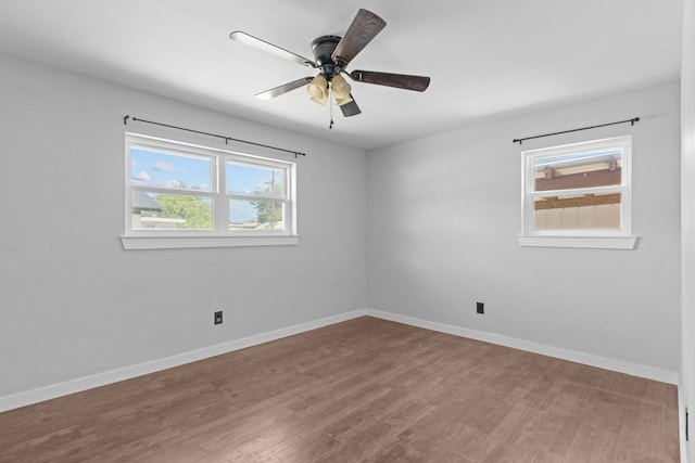 spare room featuring wood finished floors, baseboards, and ceiling fan