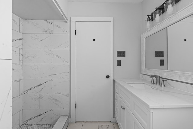 full bathroom with marble look tiles, vanity, and a shower stall