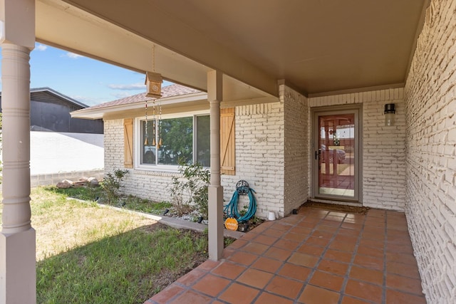 doorway to property featuring brick siding and a yard