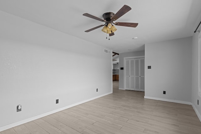 unfurnished room featuring ceiling fan, baseboards, and light wood-style floors
