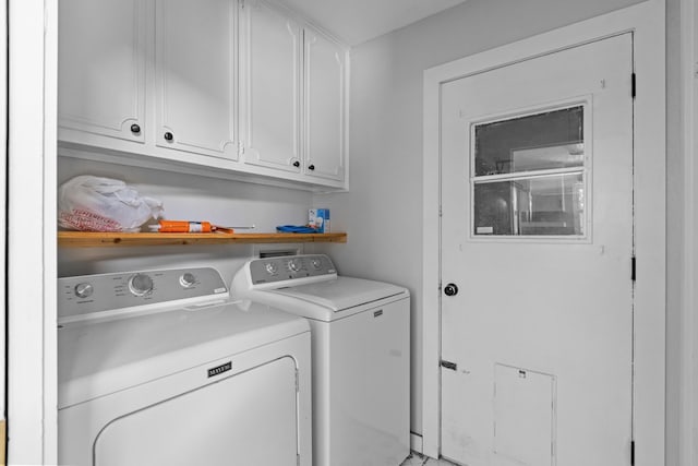 washroom featuring separate washer and dryer and cabinet space