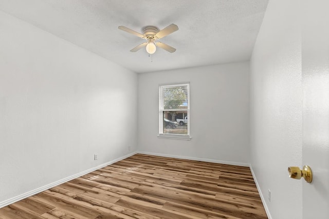 spare room with hardwood / wood-style floors and ceiling fan