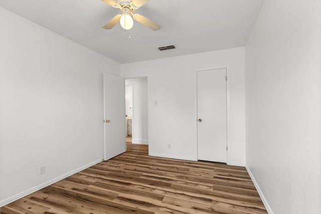 unfurnished bedroom featuring ceiling fan, dark hardwood / wood-style flooring, and a closet