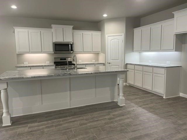 3117 Blue Quail Ct, Midland, TX 79705 - kitchen featuring appliances with stainless steel finishes, a sink, recessed lighting, a kitchen island with sink, and dark wood-style flooring