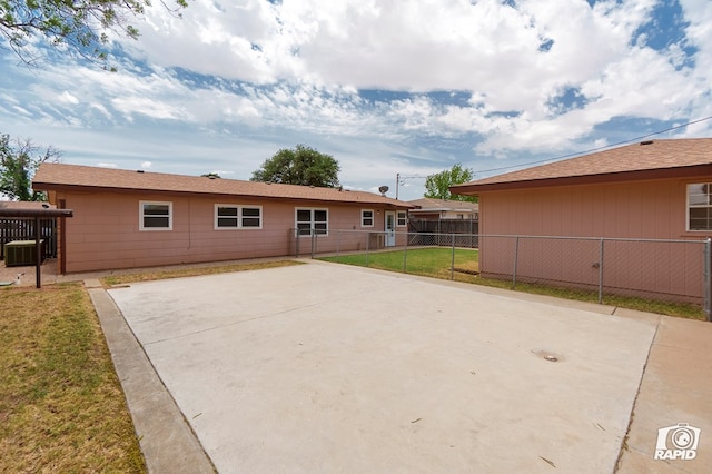 back of property with central AC unit, fence, a patio area, and a lawn