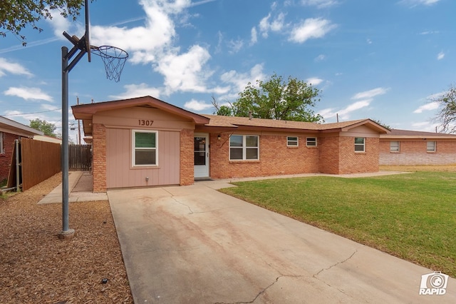 single story home with brick siding, driveway, fence, and a front yard