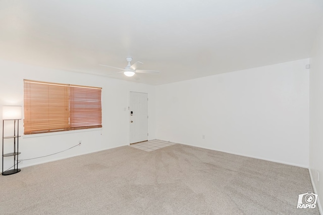spare room with a ceiling fan and light carpet