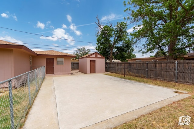 view of patio / terrace featuring an outdoor structure, a storage shed, and a fenced backyard