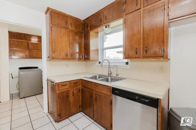 kitchen featuring a sink, stainless steel dishwasher, light countertops, and washer / clothes dryer