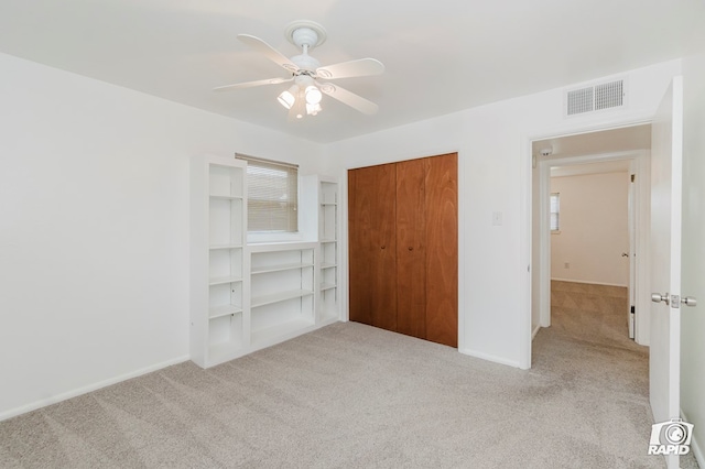 unfurnished bedroom with carpet, a closet, baseboards, and visible vents