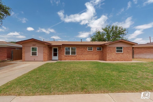ranch-style home with concrete driveway, brick siding, a front lawn, and fence