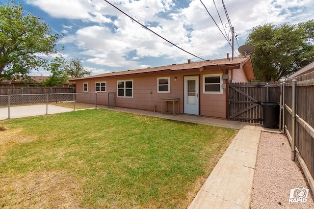 rear view of house with a yard, a gate, a fenced backyard, and a patio