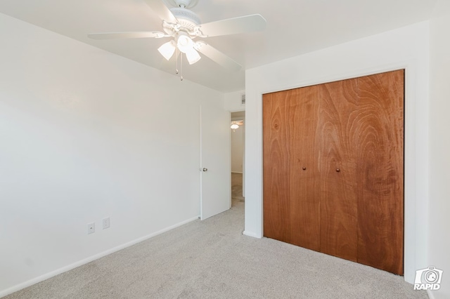 unfurnished bedroom with baseboards, a closet, a ceiling fan, and carpet
