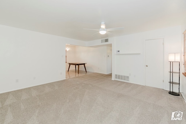 carpeted spare room with a ceiling fan, baseboards, and visible vents