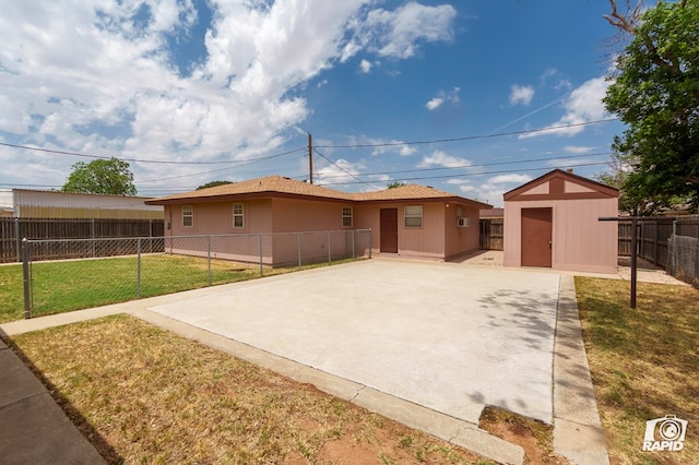 single story home featuring an outdoor structure, a front yard, a fenced backyard, a shed, and a patio area