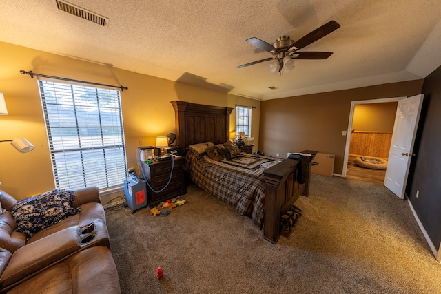 4001 Dyer Cir, Midland, TX 79707 - carpeted bedroom with multiple windows, a textured ceiling, a ceiling fan, and connected bathroom