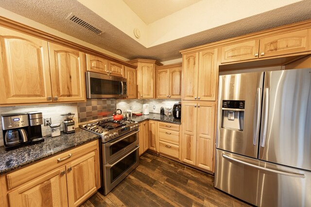 4001 Dyer Cir, Midland, TX 79707 - kitchen with stainless steel appliances, dark wood finished floors, backsplash, dark stone counters, and light brown cabinets