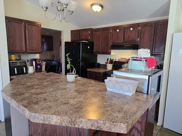 kitchen with under cabinet range hood, vaulted ceiling, an inviting chandelier, black appliances, and separate washer and dryer