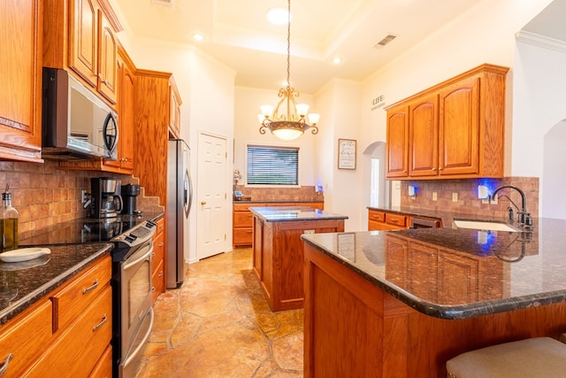 404 SW 21st St, Seminole, TX 79360 - kitchen with appliances with stainless steel finishes, a sink, crown molding, a center island, and arched walkways