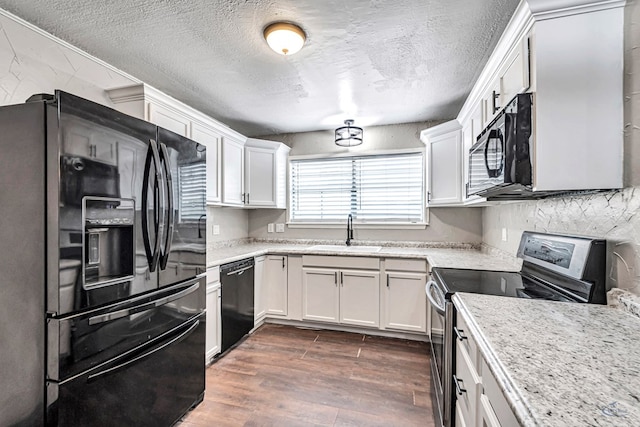 14038 W County Rd 123, Odessa, TX 79765 - kitchen with black appliances, dark wood finished floors, white cabinetry, a textured ceiling, and light stone counters