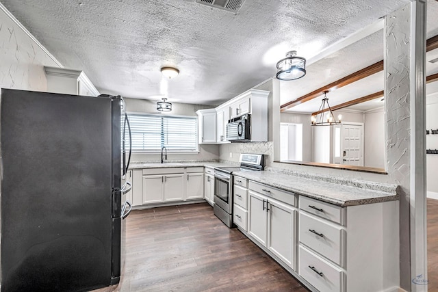 14038 W County Rd 123, Odessa, TX 79765 - kitchen with stainless steel appliances, dark wood-type flooring, white cabinets, a textured ceiling, and light stone counters