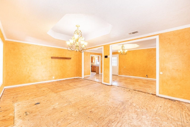 spare room featuring crown molding, a chandelier, visible vents, and a raised ceiling