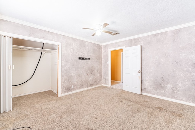 unfurnished bedroom with ornamental molding, carpet, a closet, and baseboards