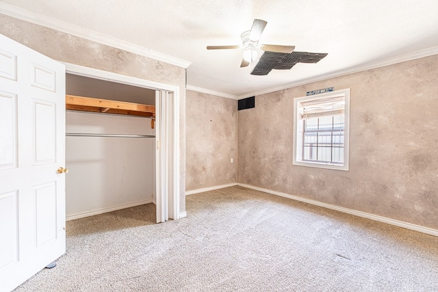 unfurnished bedroom featuring a closet, baseboards, ornamental molding, ceiling fan, and carpet floors