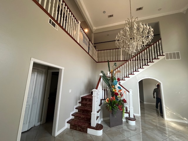 7311 Westmoore Rd, Odessa, TX 79764 - stairway featuring arched walkways, a towering ceiling, ornamental molding, and a chandelier