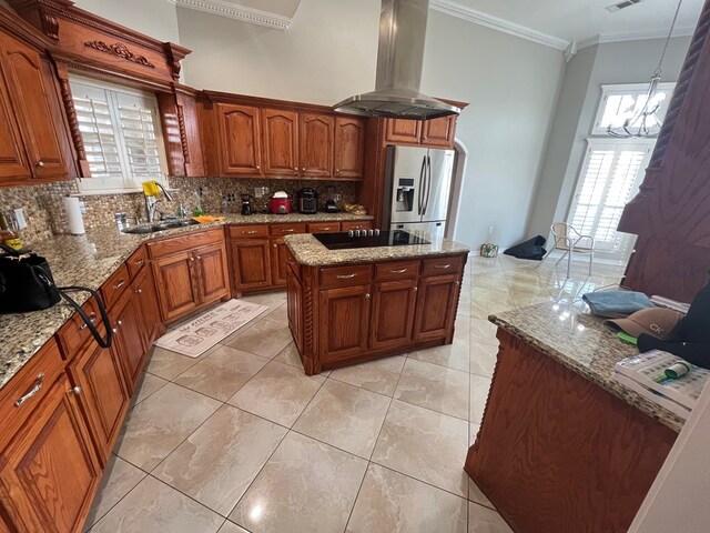 7311 Westmoore Rd, Odessa, TX 79764 - kitchen featuring island exhaust hood, stainless steel fridge with ice dispenser, decorative backsplash, crown molding, and plenty of natural light