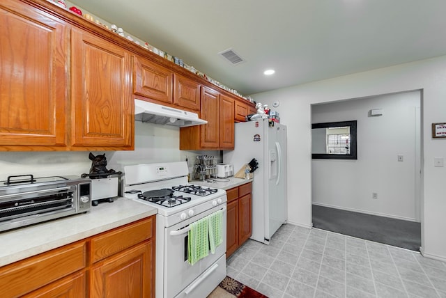 401 Brookover Cir, Odessa, TX 79763 - kitchen with white appliances, under cabinet range hood, light countertops, brown cabinetry, and recessed lighting
