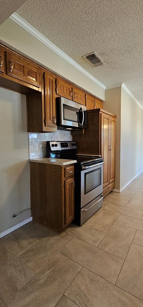 2304 Regal Pl, Midland, TX 79707 - kitchen with appliances with stainless steel finishes, crown molding, a textured ceiling, backsplash, and baseboards