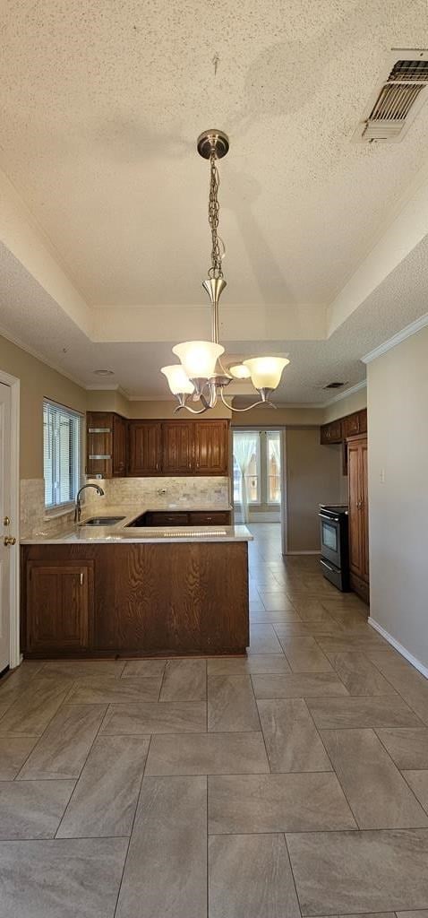 2304 Regal Pl, Midland, TX 79707 - kitchen with a raised ceiling, range with electric cooktop, tasteful backsplash, a textured ceiling, and a chandelier