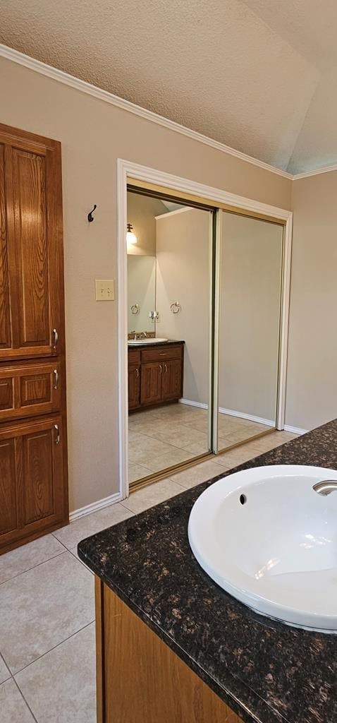 2304 Regal Pl, Midland, TX 79707 - bathroom with vanity, ornamental molding, and tile patterned flooring