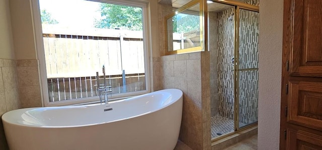 2304 Regal Pl, Midland, TX 79707 - bathroom featuring tile walls, healthy amount of natural light, a freestanding bath, and a shower stall
