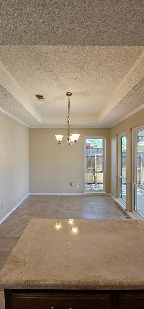 2304 Regal Pl, Midland, TX 79707 - spare room featuring a tray ceiling, a textured ceiling, a chandelier, baseboards, and crown molding