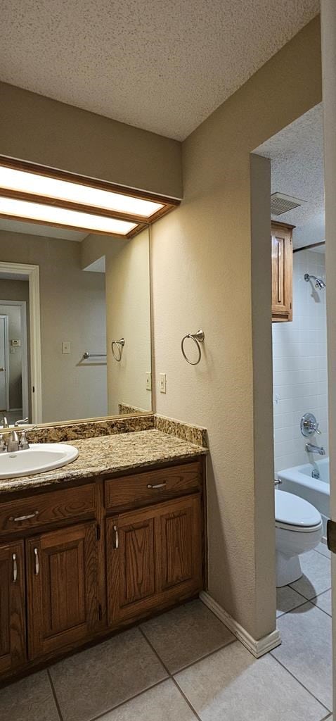 2304 Regal Pl, Midland, TX 79707 - full bath with toilet, tile patterned flooring, a textured ceiling, vanity, and shower / bathtub combination
