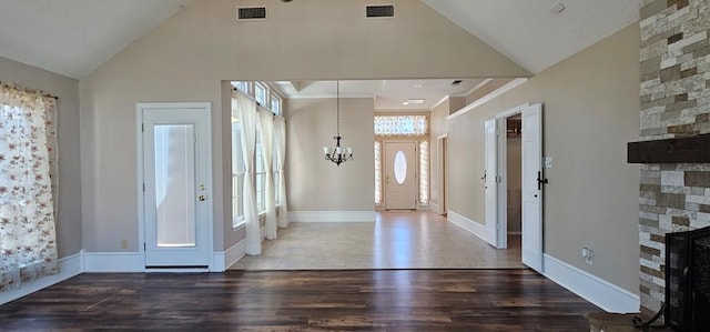 2304 Regal Pl, Midland, TX 79707 - foyer entrance with a stone fireplace, a chandelier, wood finished floors, high vaulted ceiling, and baseboards