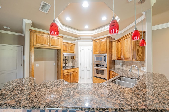 104 Waimea Dr, Odessa, TX 79762 - kitchen with appliances with stainless steel finishes, ornamental molding, a peninsula, tasteful backsplash, and brown cabinetry