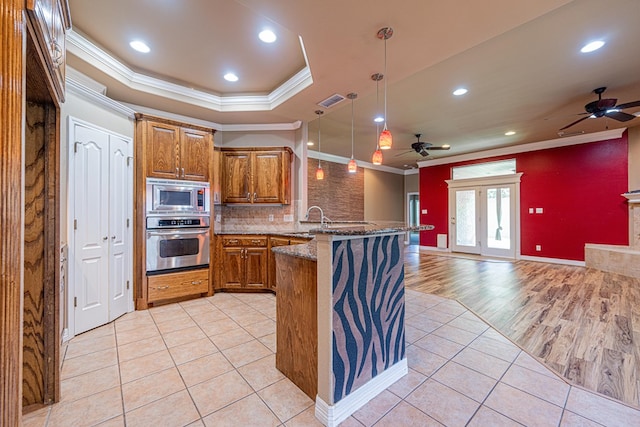 104 Waimea Dr, Odessa, TX 79762 - kitchen featuring stainless steel appliances, ornamental molding, ceiling fan, brown cabinetry, and open floor plan