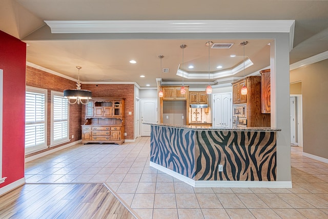 104 Waimea Dr, Odessa, TX 79762 - kitchen with ornamental molding, stainless steel microwave, stone countertops, light tile patterned floors, and brown cabinetry