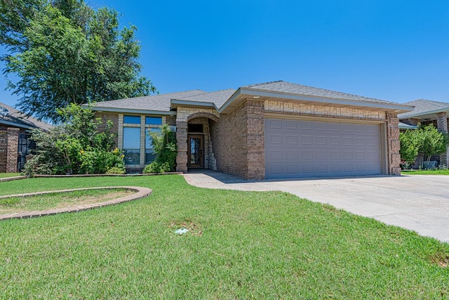 104 Waimea Dr, Odessa, TX 79762 - view of front of home featuring driveway, brick siding, a front lawn, and a garage