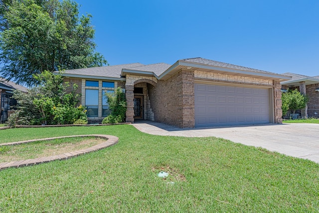 104 Waimea Dr, Odessa, TX 79762 - view of front of house with driveway, a garage, a front yard, brick siding, and roof with shingles