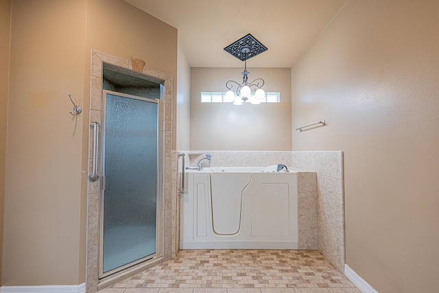 104 Waimea Dr, Odessa, TX 79762 - full bathroom with a shower stall, a bath, a chandelier, and tile patterned floors