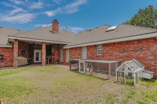 7 Amethyst Cv, Odessa, TX 79762 - rear view of house with exterior structure, roof with shingles, a lawn, a chimney, and brick siding
