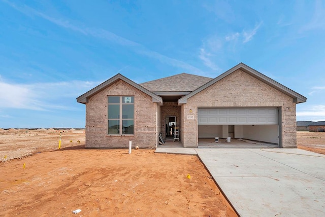 1332 Loess St, Midland, TX 79705 - view of front facade with a garage, brick siding, concrete driveway, and roof with shingles