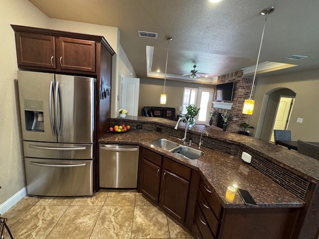 6111 Sun Tea Way, Midland, TX 79705 - kitchen featuring stainless steel appliances, a tray ceiling, a sink, a ceiling fan, and arched walkways