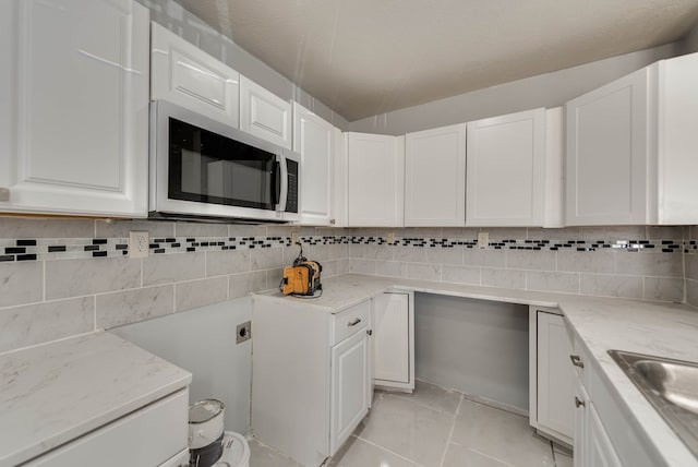 1009 S Terrell St, Midland, TX 79701 - kitchen with stainless steel microwave, light stone counters, and white cabinetry